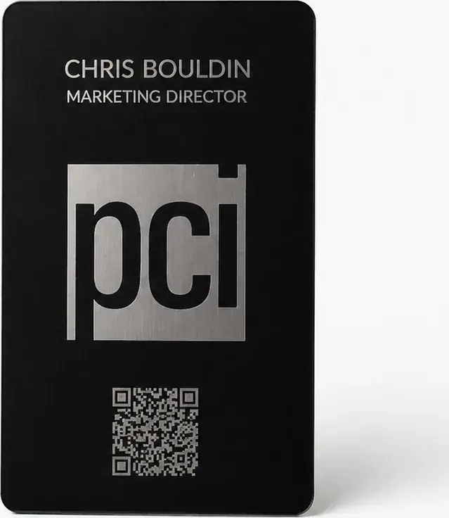 A portrait-orientation Bümpis metal card etched with a company logo, name and QR code
