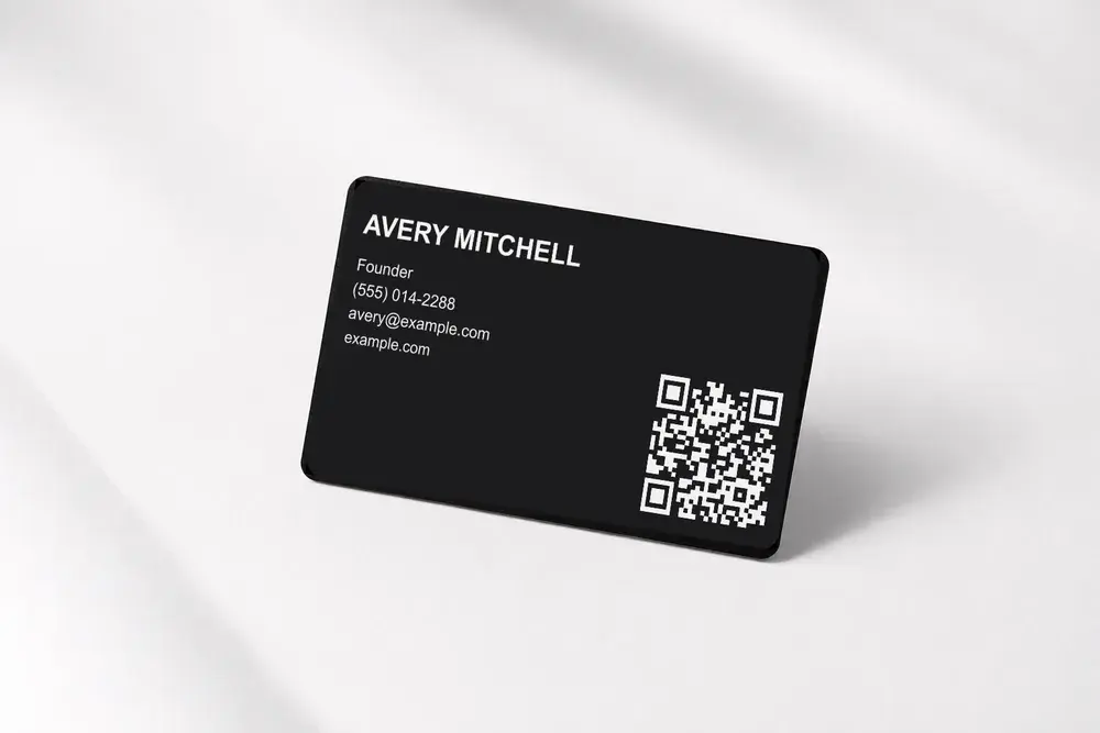A Bümpis metal card etched with a name, title, phone, email and website